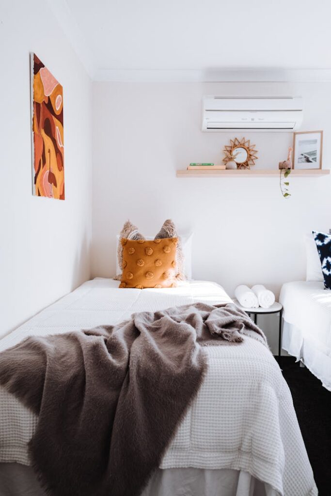 pexels photo 4993065 A minimalist bedroom featuring a single bed with soft textures, warm decor, and modern design.